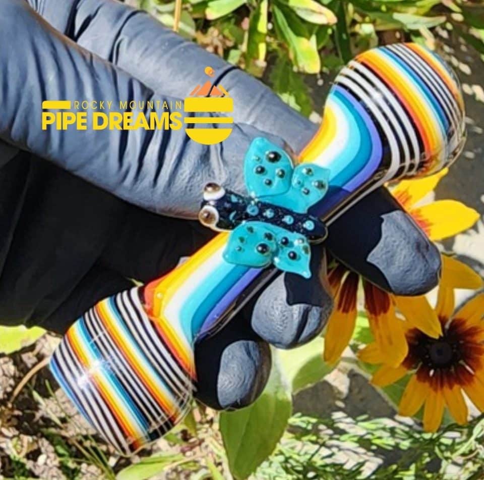 3.8inches lonthg and flared at both ends with blue, red, black, white, yellow line work and adorned with a large butterfly