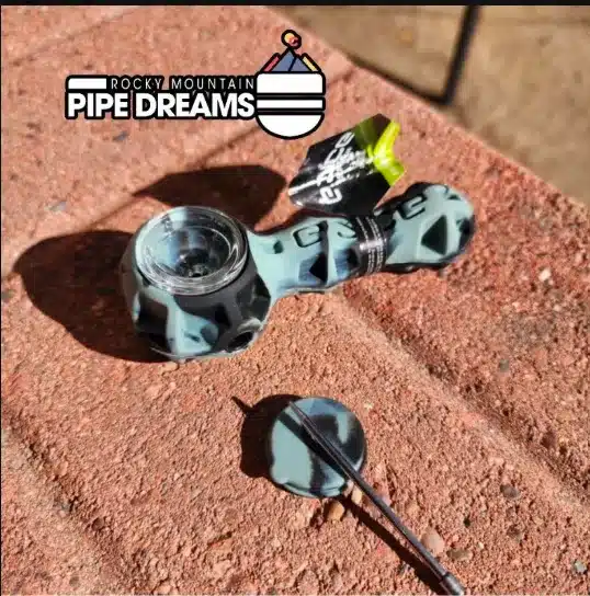 The silicone Eyce Spoon hand pipe in grey and black colors, inlaid replacable borosilicate glass bowl, built in poker and material storage all in one.